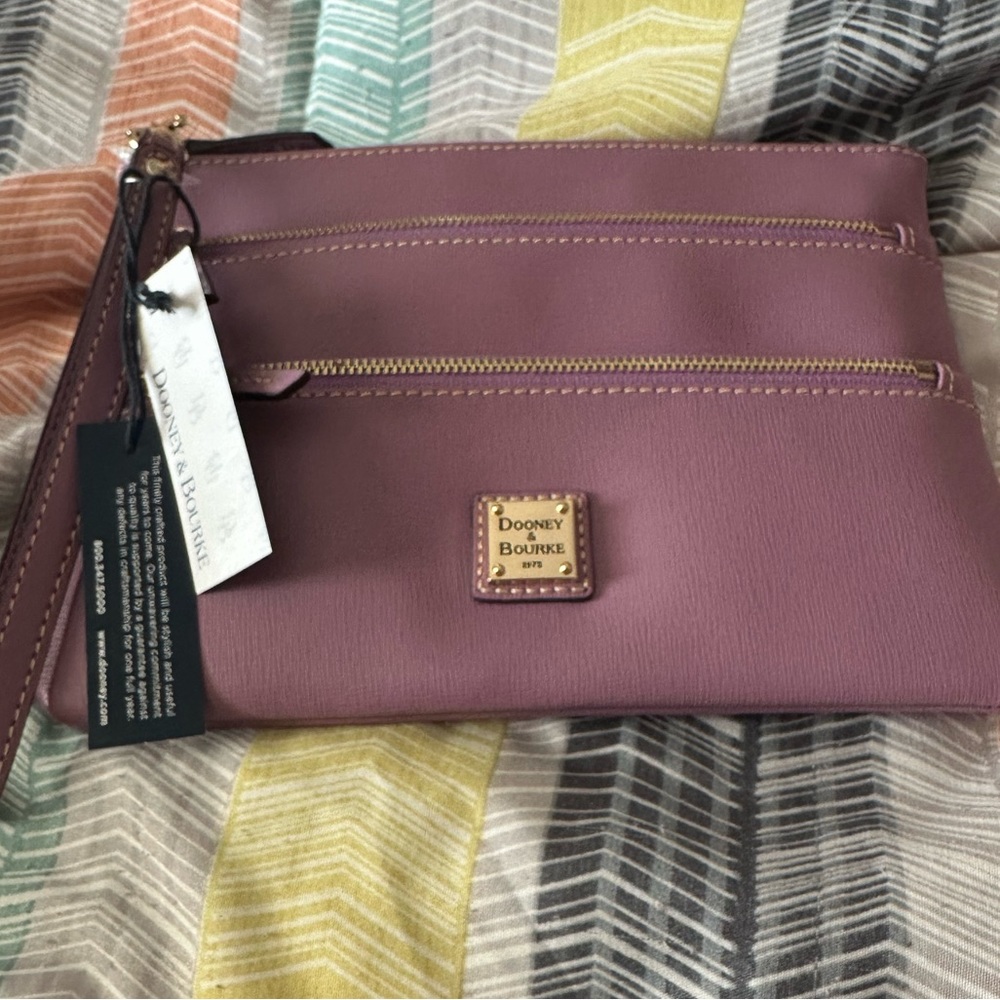 Dooney Triple zip wrist clutch. New with tags never used. The color is dark mauv